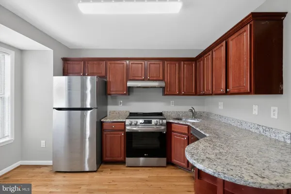 a kitchen with a refrigerator sink and cabinets