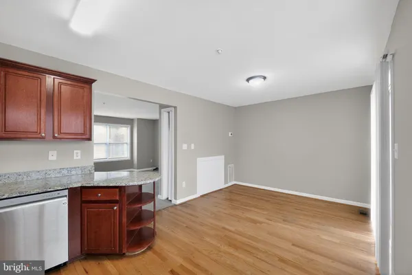 a kitchen with granite countertop a sink cabinets and wooden floor