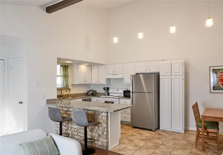 a kitchen with refrigerator a table and chairs