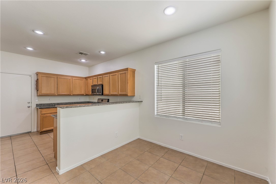 10939 Paradise Road Henderson, NV 89052 - Photo 10 of 36 A well-appointed kitchen boasts sleek countertops and ample cabinetry, ready for culinary endeavors.