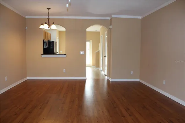 a view of a room with wooden floor and chandelier