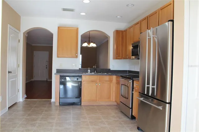 a kitchen with stainless steel appliances granite countertop a refrigerator and a sink