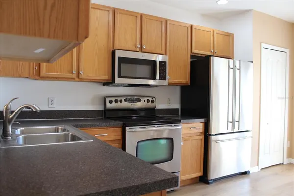 a kitchen with stainless steel appliances granite countertop a refrigerator sink and microwave