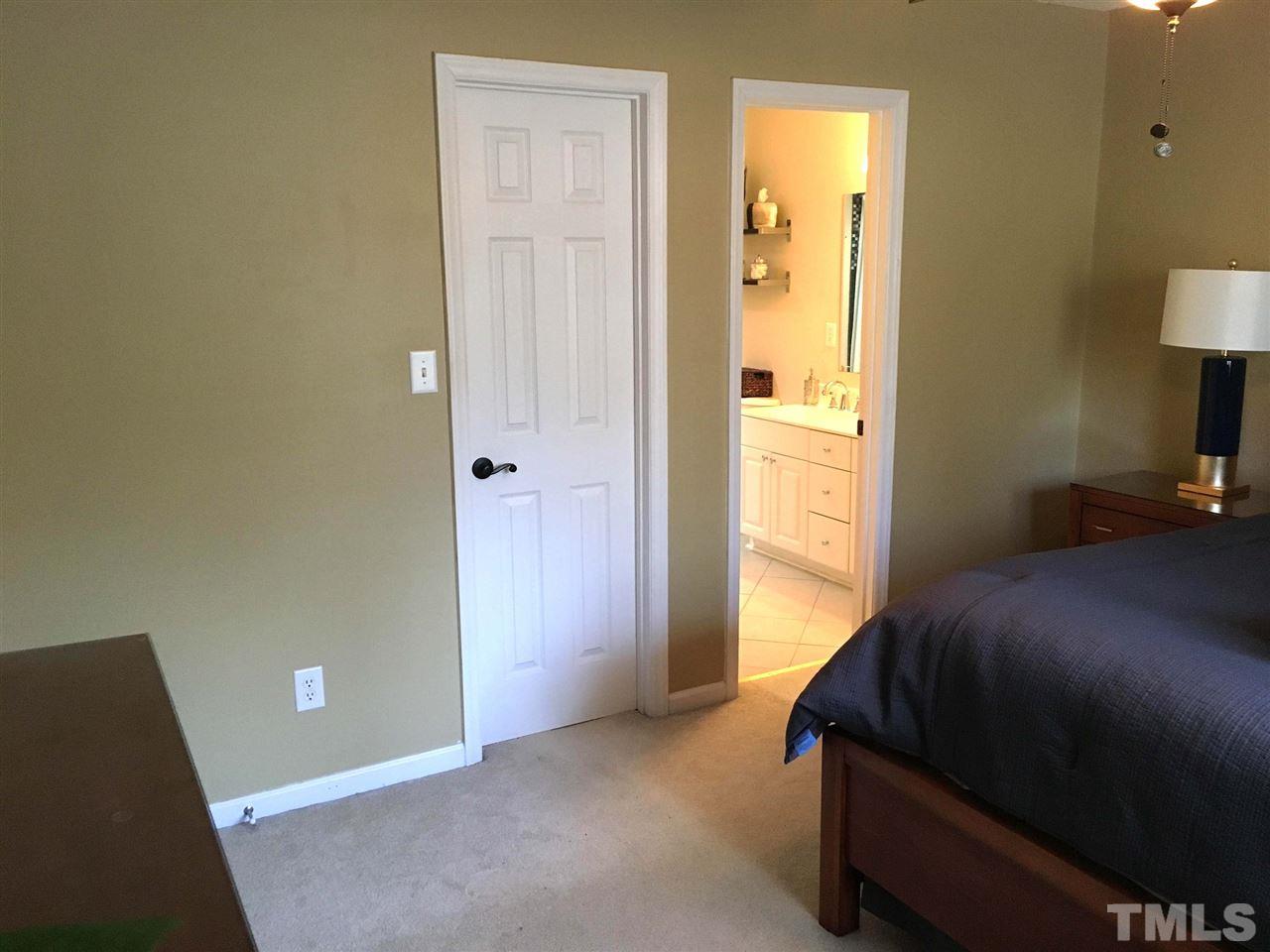 124 Fieldspring Lane Raleigh, NC 27606 - Photo 15 of 24 a bedroom with a bed and a lamp on table