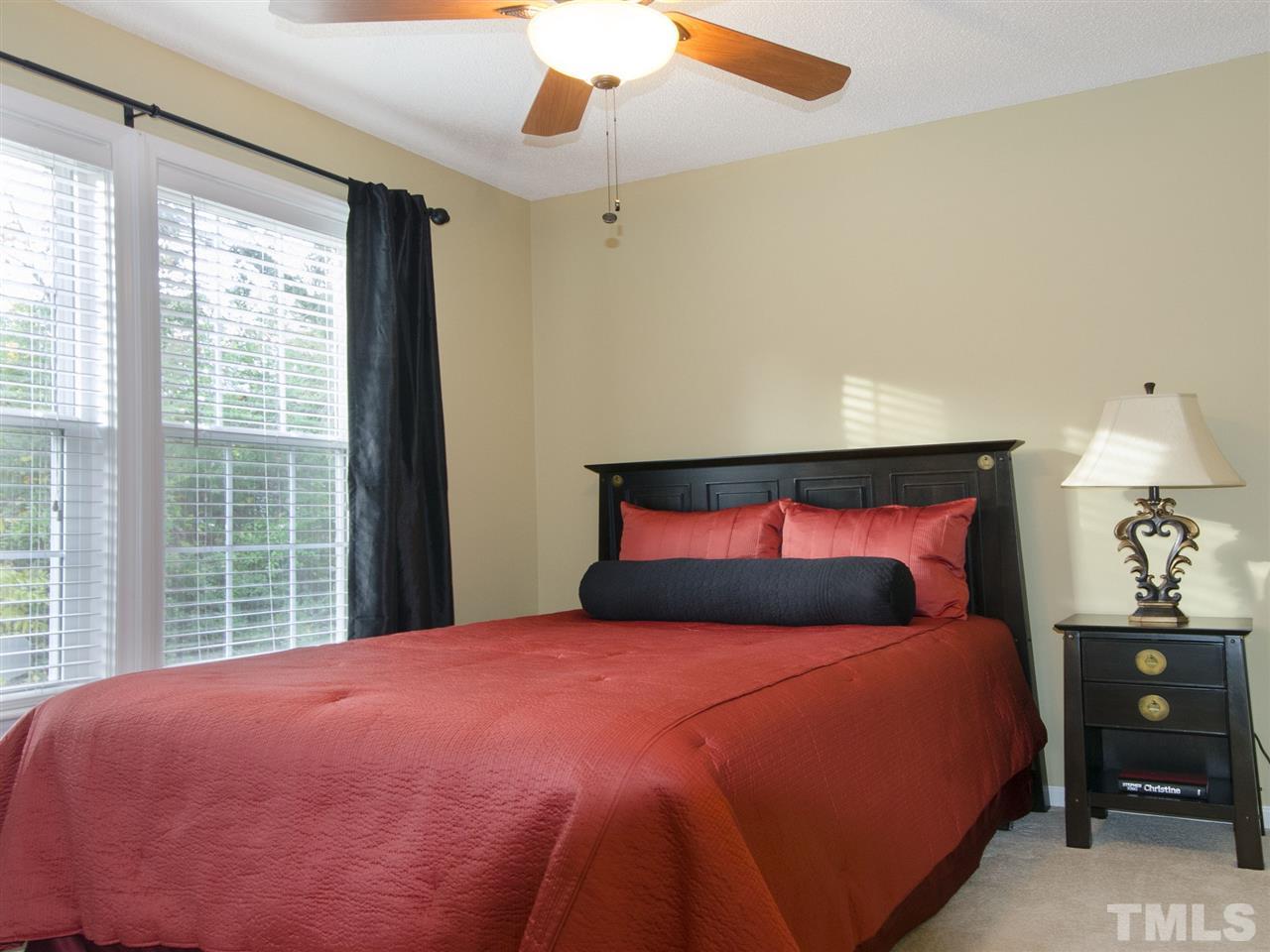 124 Fieldspring Lane Raleigh, NC 27606 - Photo 18 of 24 a bedroom with a large bed and a chandelier