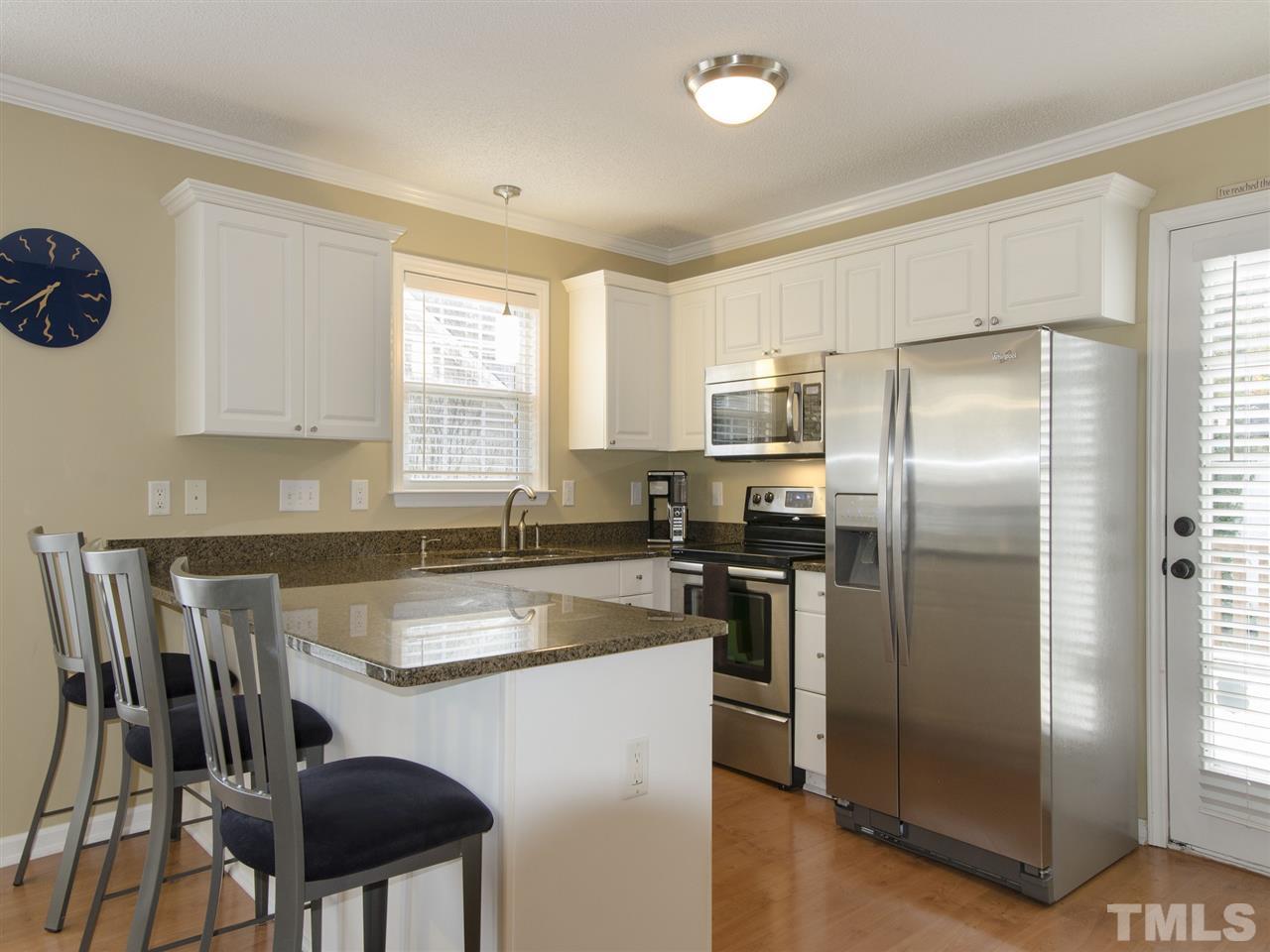 124 Fieldspring Lane Raleigh, NC 27606 - Photo 8 of 24 a kitchen with a refrigerator a stove a sink and chairs