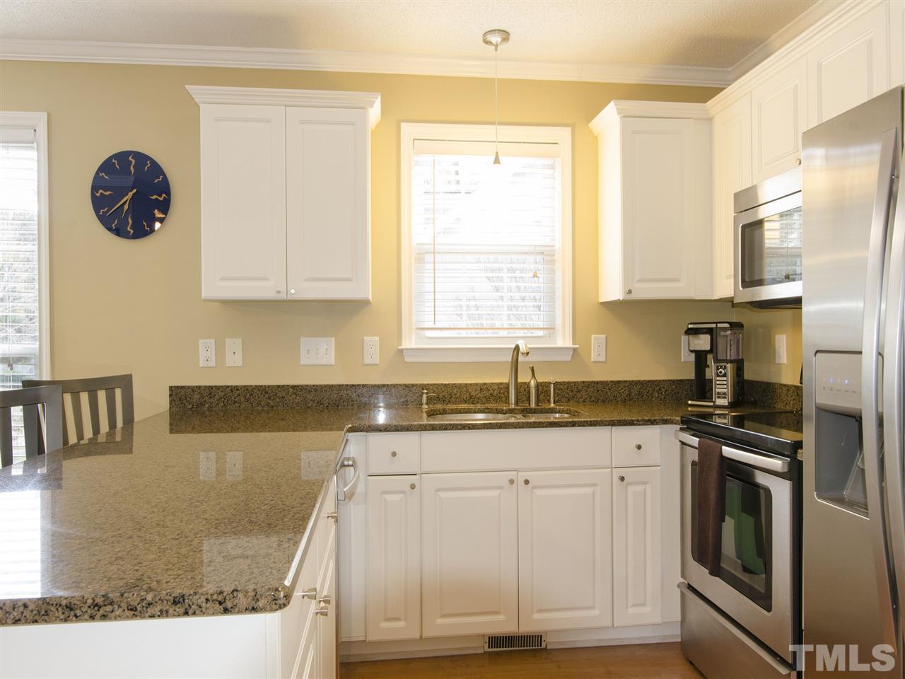 124 Fieldspring Lane Raleigh, NC 27606 - Photo 9 of 24 a kitchen with granite countertop a sink a stove and cabinets