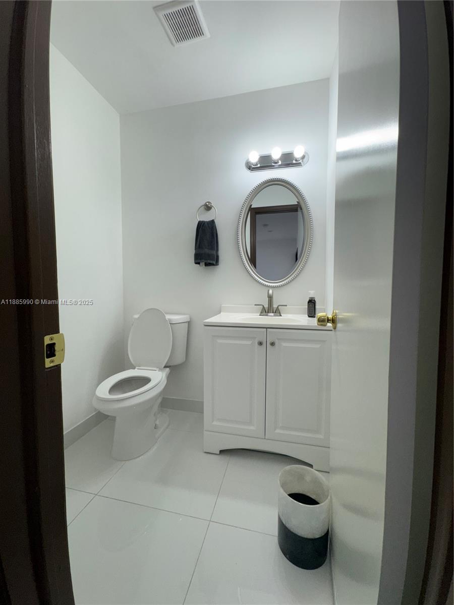 11111 Southwest 147th Court Miami, FL 33196 - Photo 27 of 42 a bathroom with a toilet a sink and mirror