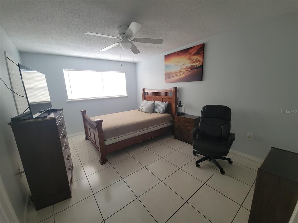 5317 Curry Ford Road, Unit 20 Orlando, FL 32812 - Photo 15 of 18 a bedroom with a bed and chair