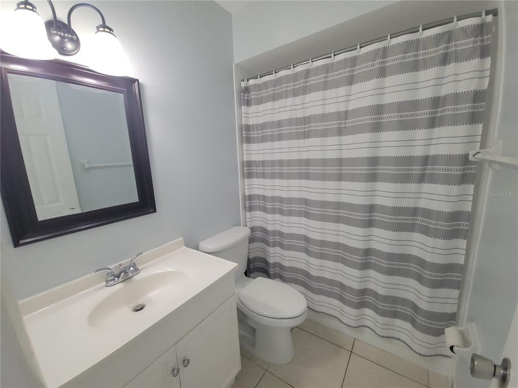 5317 Curry Ford Road, Unit 20 Orlando, FL 32812 - Photo 10 of 18 a bathroom with a sink a toilet and mirror