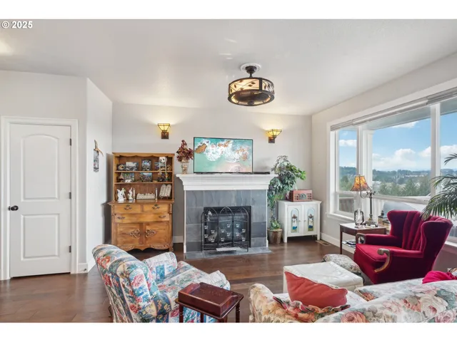 a living room with furniture large window and a fireplace