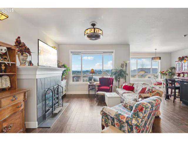 a living room with furniture and a dining table with wooden floor