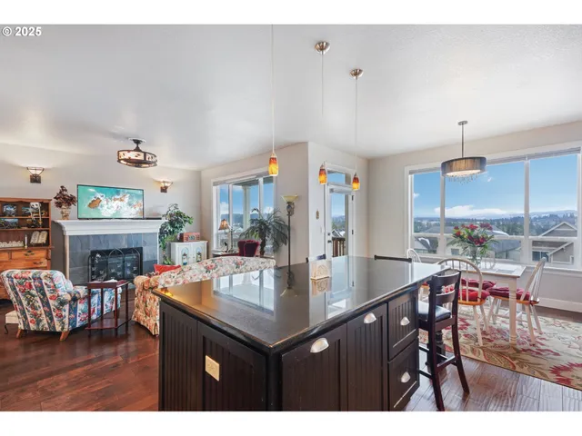 a kitchen with stainless steel appliances granite countertop a table chairs and a refrigerator