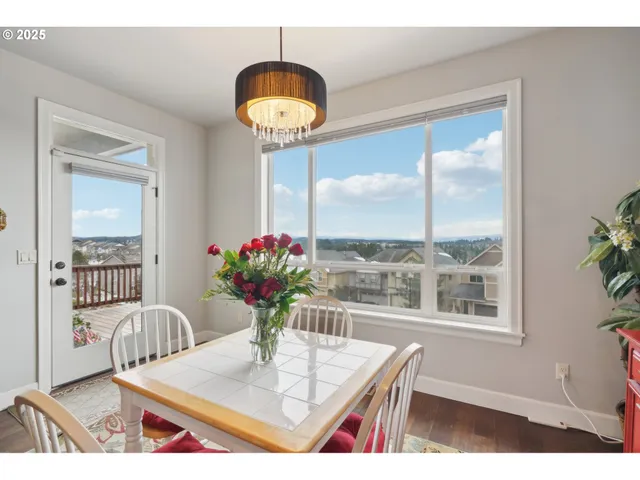 a dining room with furniture a potted plant and wooden floor