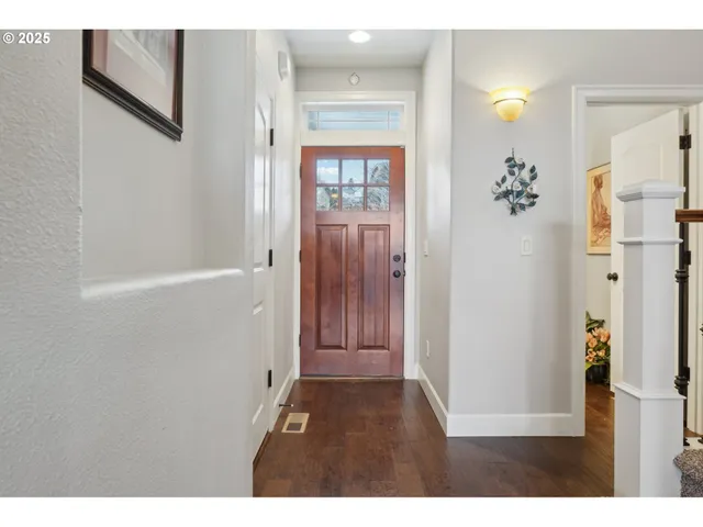 a view of a hallway with wooden floor and windows