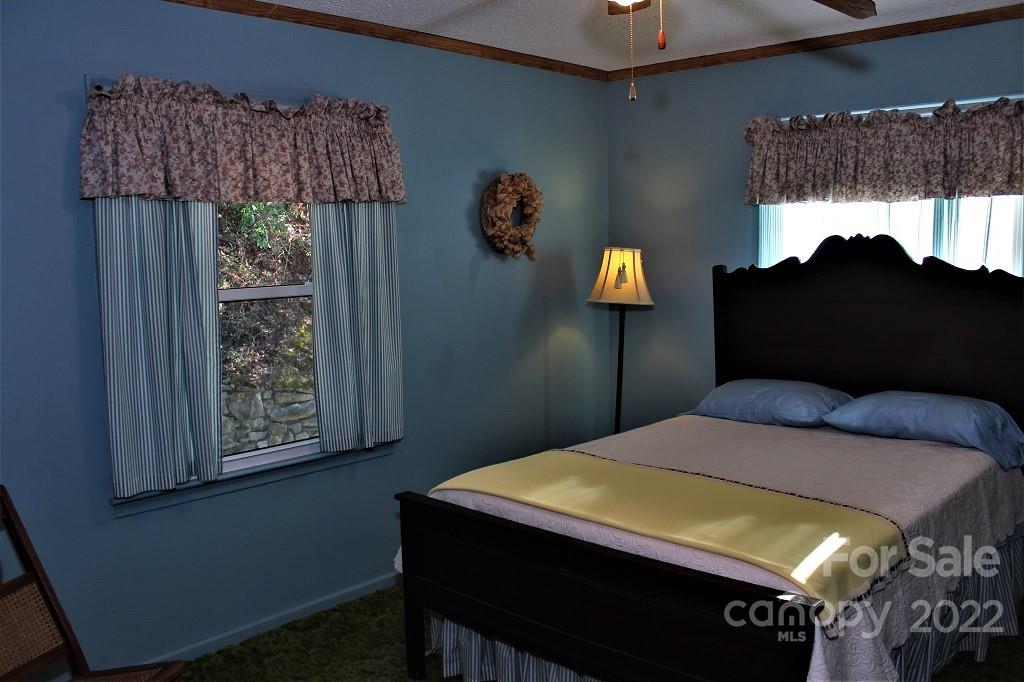 789 Tobacco Branch Road Almond, NC 28702 - Photo 20 of 42 a bedroom with a bed a window and lamp