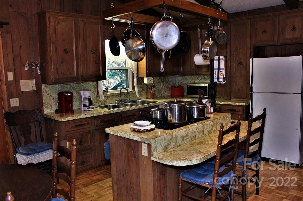789 Tobacco Branch Road Almond, NC 28702 - Photo 9 of 42 a kitchen with granite countertop a table chairs a stove a dining table and chairs