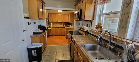 a view of a kitchen with fridge and workspace