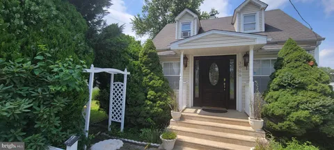 a view of a house with backyard and trees