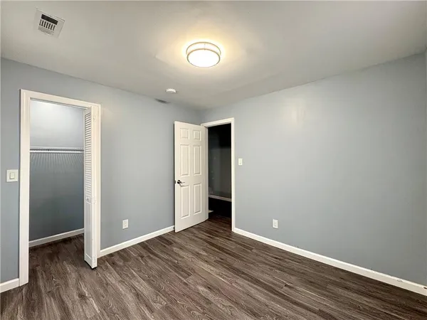 a view of an empty room with wooden floor