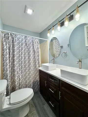 a bathroom with a toilet a sink and mirror