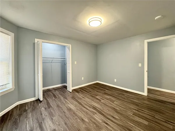 an empty room with wooden floor and closet