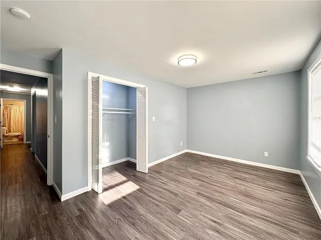 a view of an empty room with wooden floor