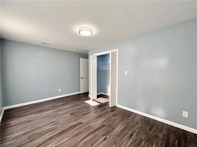 a view of an empty room with wooden floor