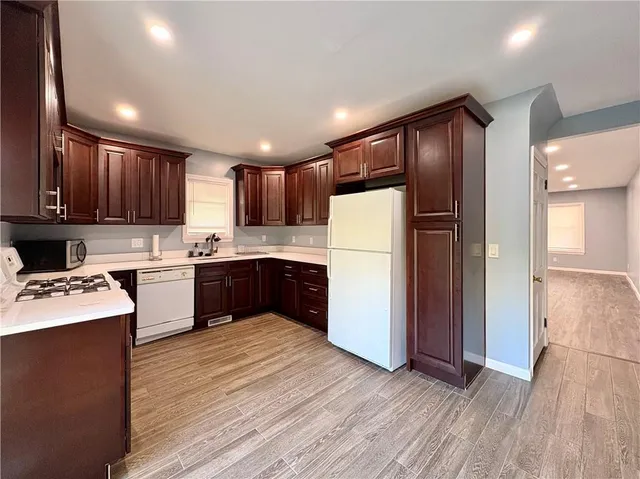 a kitchen with refrigerator cabinets and wooden floor