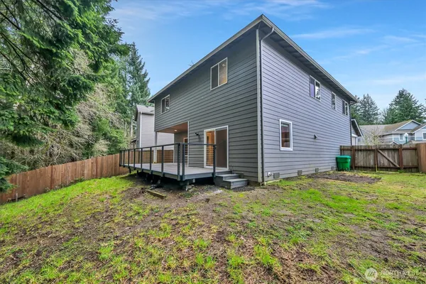 a view of a house with a yard and wooden fence