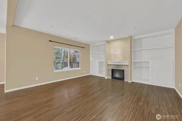 wooden floor fireplace and windows in an empty room