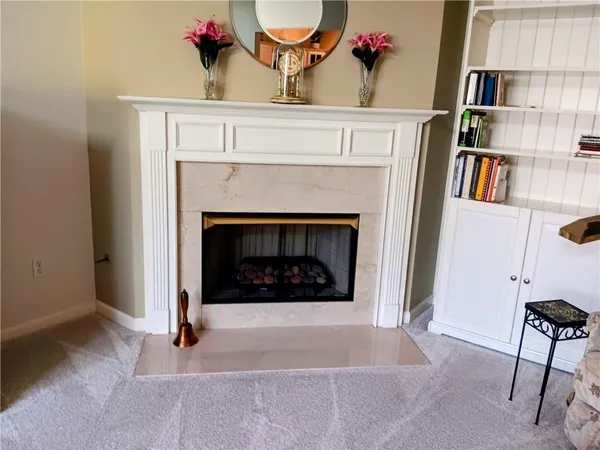 a living room with a fireplace and book shelf