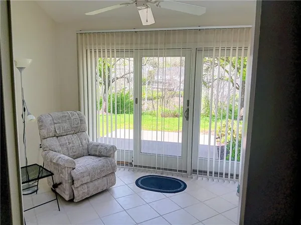 a living room with furniture and a floor to ceiling window