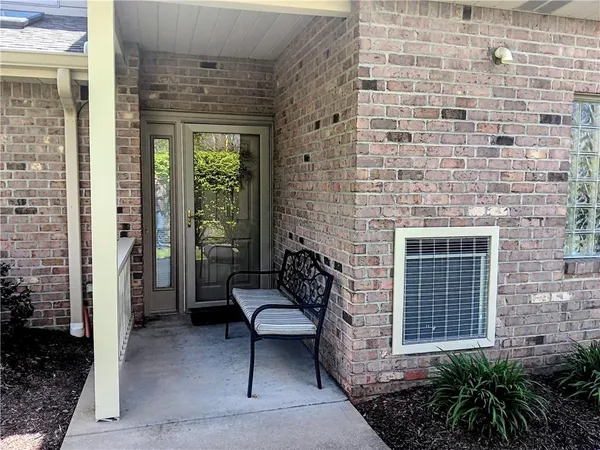 a brick building with a bench and a potted plant