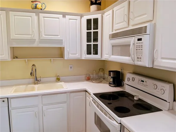a kitchen with stainless steel appliances granite countertop a sink and cabinets with wooden floor