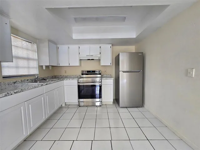 a kitchen with granite countertop a refrigerator and a sink