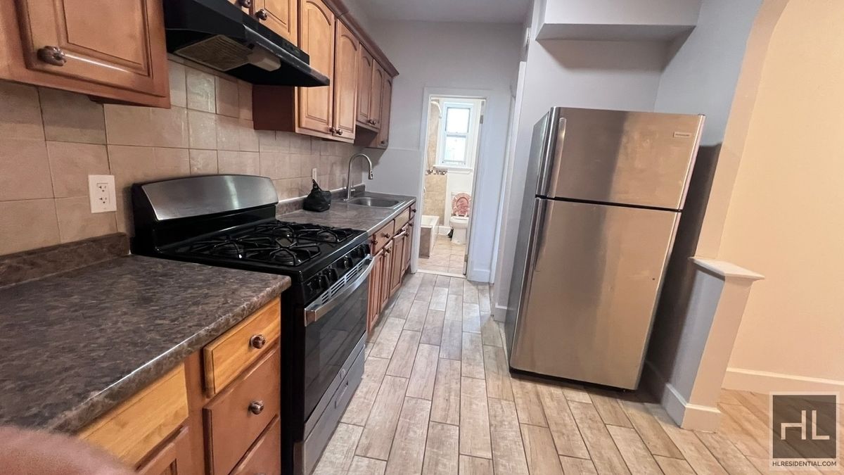 a kitchen with a refrigerator a stove and wooden floor