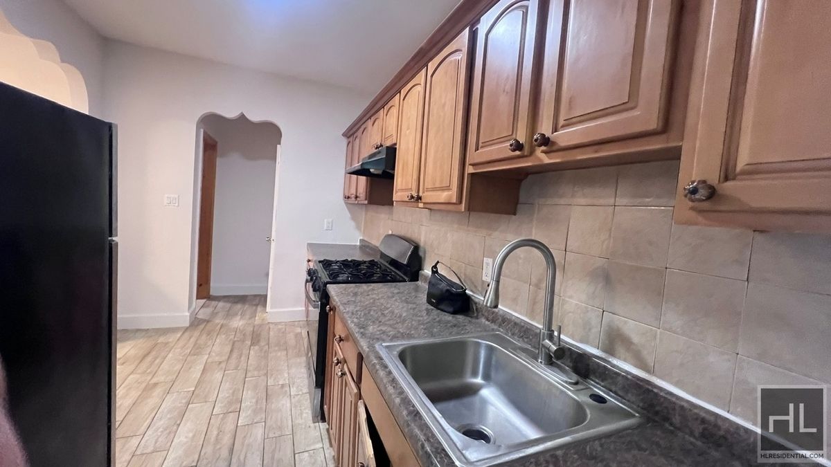 798 Miller Avenue, Unit 1 Brooklyn, NY 11207 - Photo 2 of 14 a kitchen with granite countertop a sink stainless steel appliances and cabinets