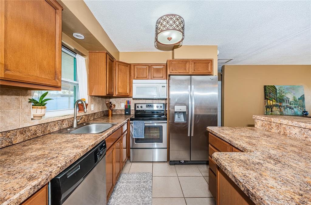 1738 Bentley Street Clearwater, FL 33755 - Photo 11 of 30 a kitchen with stainless steel appliances granite countertop a sink a stove and a refrigerator