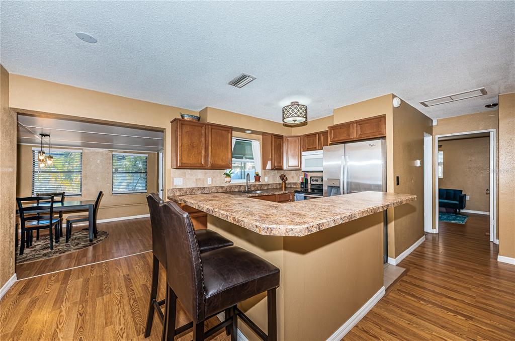 1738 Bentley Street Clearwater, FL 33755 - Photo 13 of 30 a kitchen with stainless steel appliances granite countertop dining table chairs and wooden floor