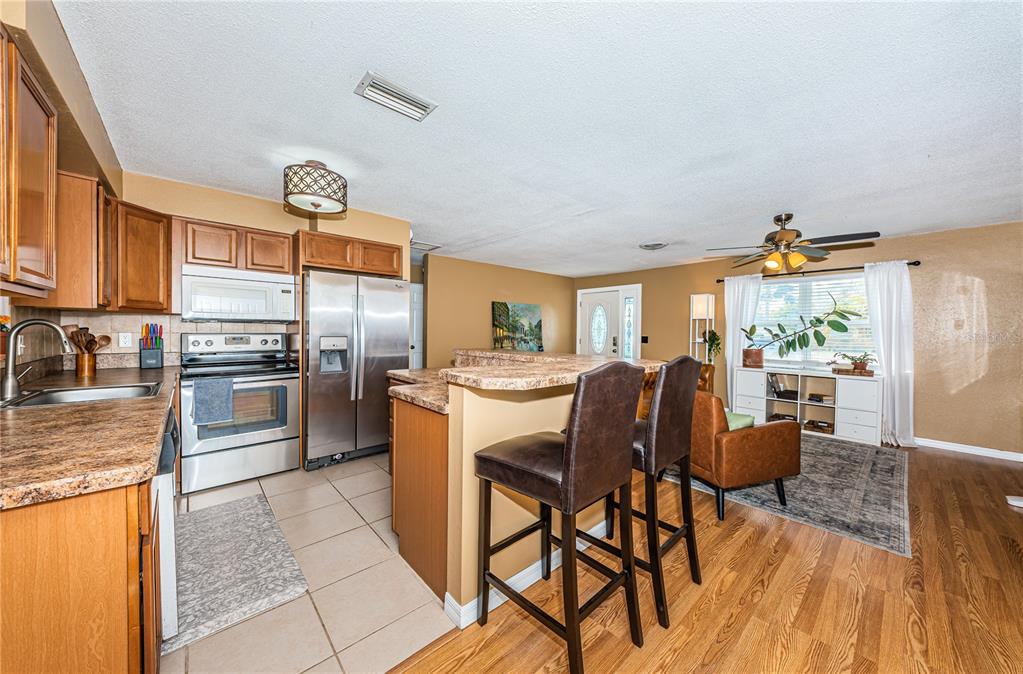 1738 Bentley Street Clearwater, FL 33755 - Photo 9 of 30 a kitchen with a table chairs microwave and cabinets