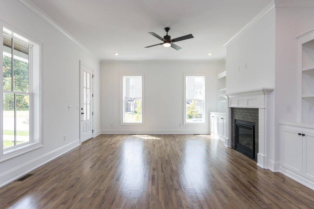 1108 Kentlands Drive Durham, NC 27713 - Photo 6 of 49 a view of an empty room with wooden floor fireplace and a window