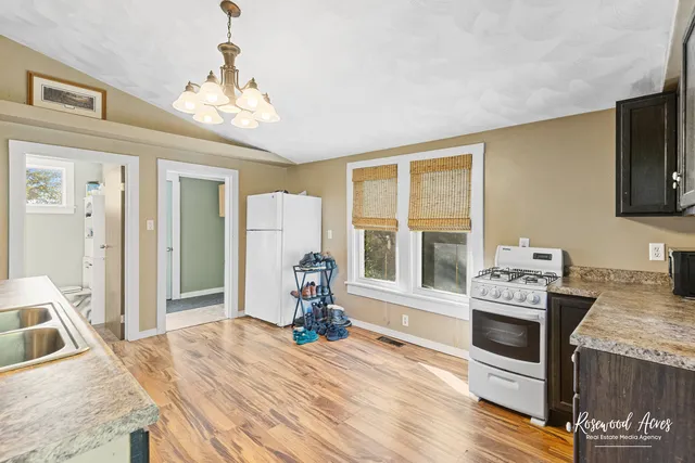 a bedroom with a bed a stove and a large window with wooden floor