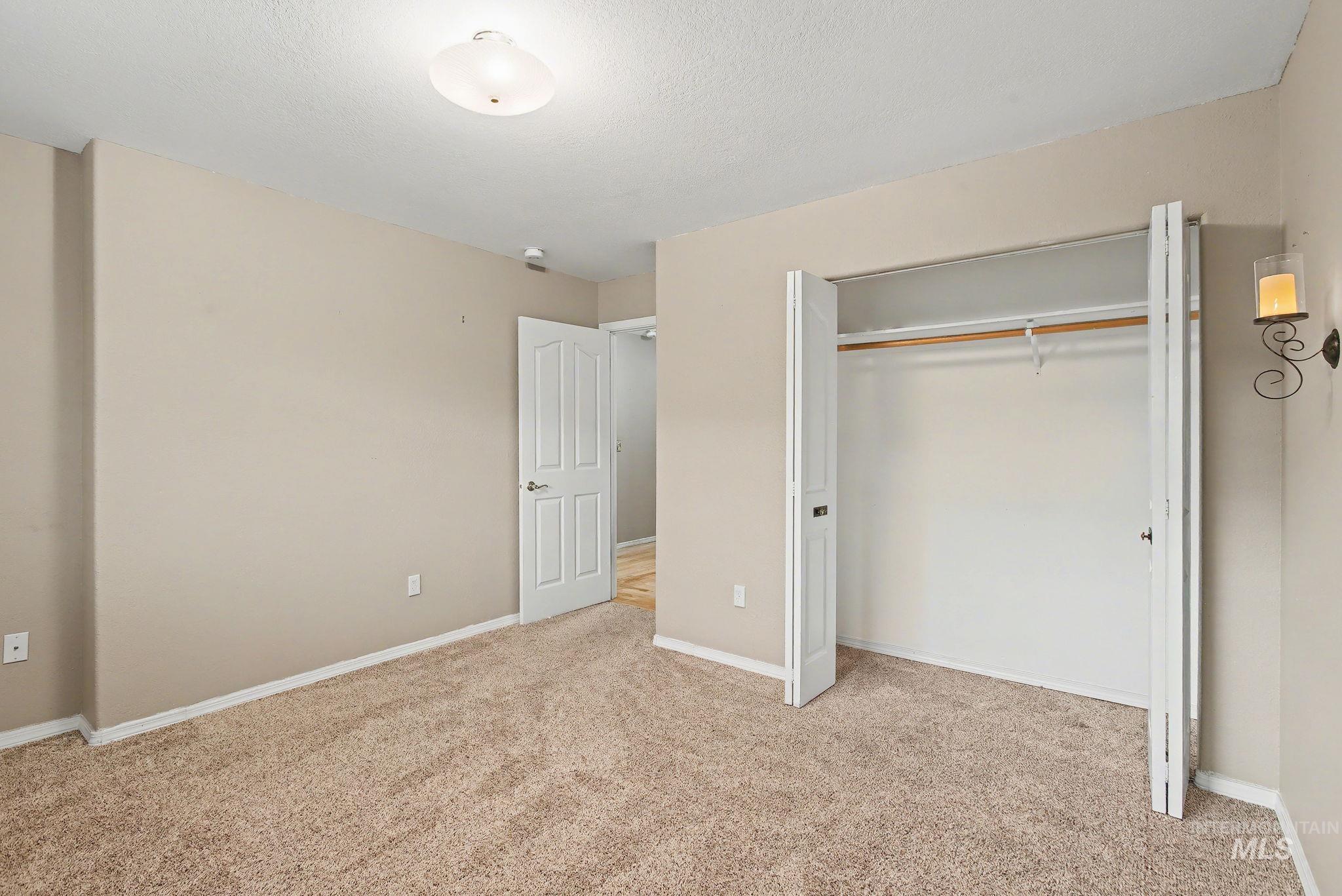 2242 Chukar Lane Clarkston, WA 99403 - Photo 29 of 41 Unfurnished bedroom with light carpet, a closet, and a textured ceiling