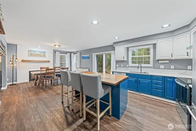 a kitchen with stainless steel appliances granite countertop a table chairs sink and cabinets