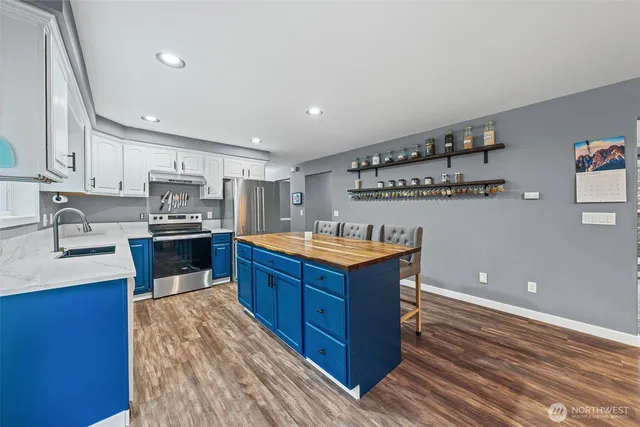 a kitchen with stainless steel appliances granite countertop a sink stove and refrigerator