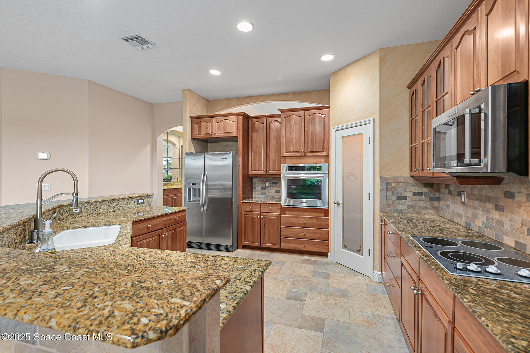 425 Baytree Drive Melbourne, FL 32940 - Photo 16 of 53 a kitchen with stainless steel appliances granite countertop a sink stove and refrigerator