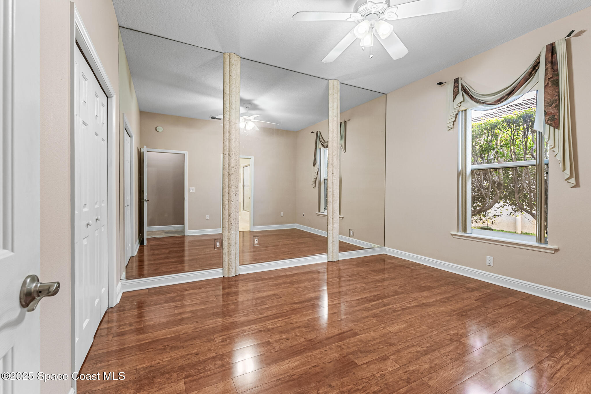 425 Baytree Drive Melbourne, FL 32940 - Photo 27 of 53 an empty room with wooden floor fan and windows