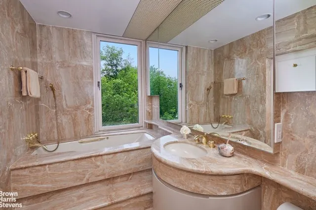 a spacious bedroom with a bed and a potted plant