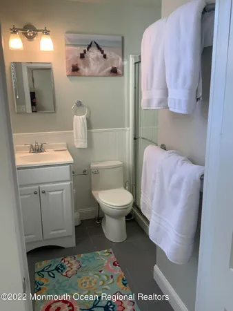 a bathroom with a toilet sink vanity and mirror